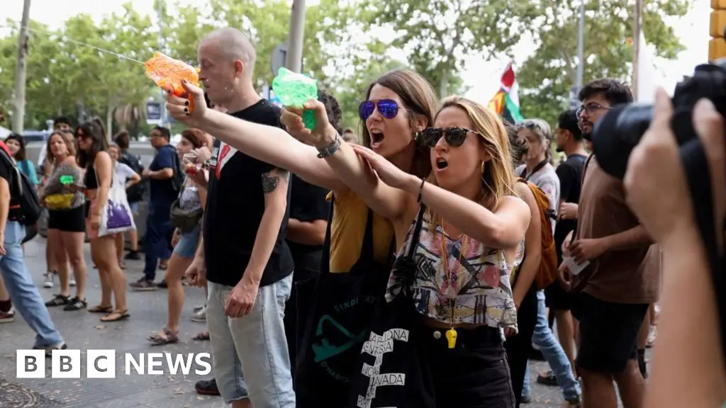 Mass tourism protesters squirt water at Barcelona tourists